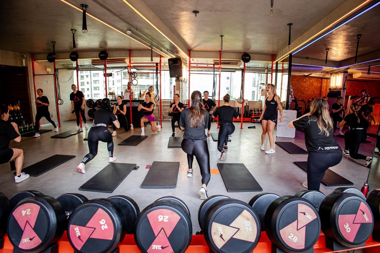 Turma executando exercício em aula de Pump Beat